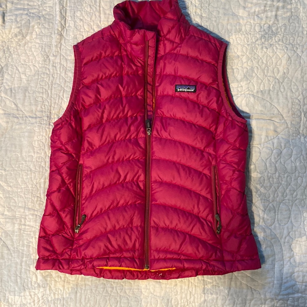 Patagonia S down filled puffy vest in pink with orange lining inside.